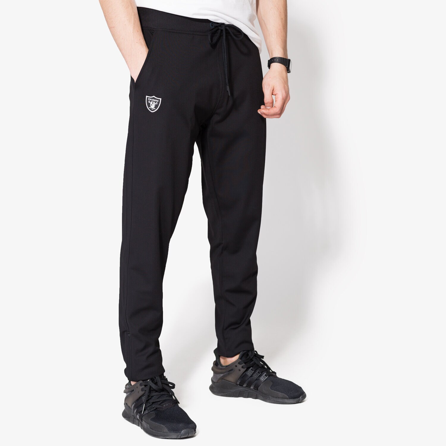 Bărbați pantaloni NEW ERA PANTALONI  BORDER EDGE TRK PANT OAK RAIDERS BLK 11372560 Negru