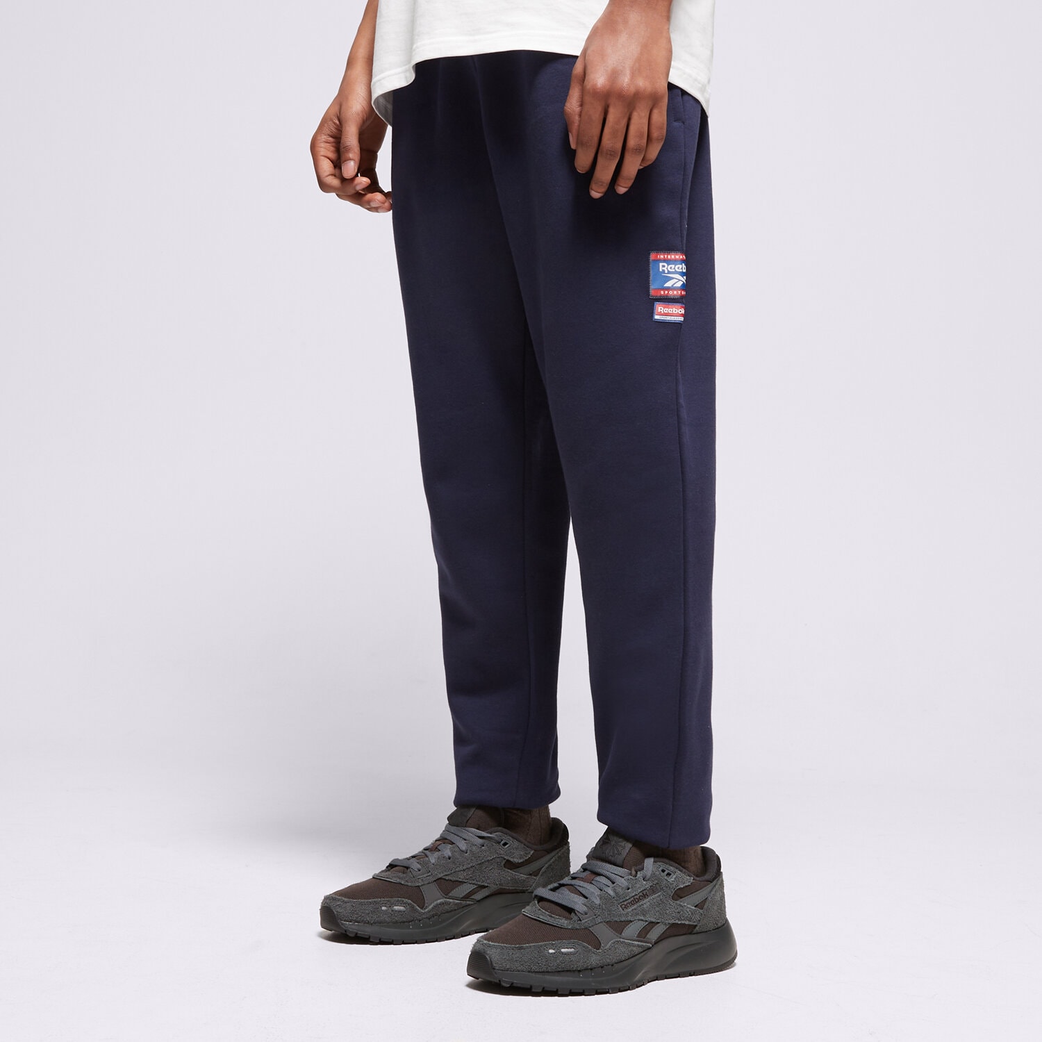 Bărbați pantaloni REEBOK PANTALONI  RI BADGE 100205446 Bleumarin